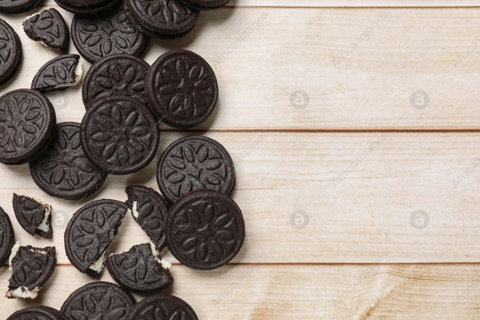 Photo of Tasty sandwich cookies on light wooden table, flat lay. Space for text