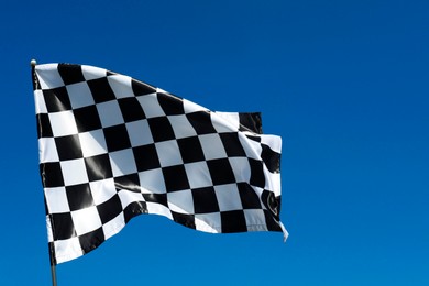 Photo of One checkered flag against blue sky outdoors, low angle view