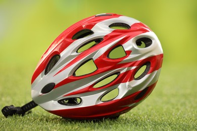 Photo of One colorful protective helmet on green grass