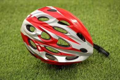 Photo of One colorful protective helmet on green grass