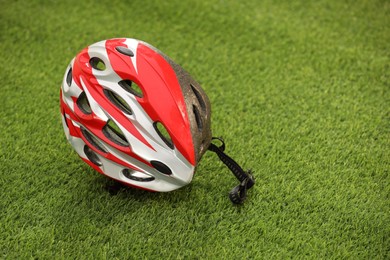 Photo of Colorful protective helmet on green grass, space for text