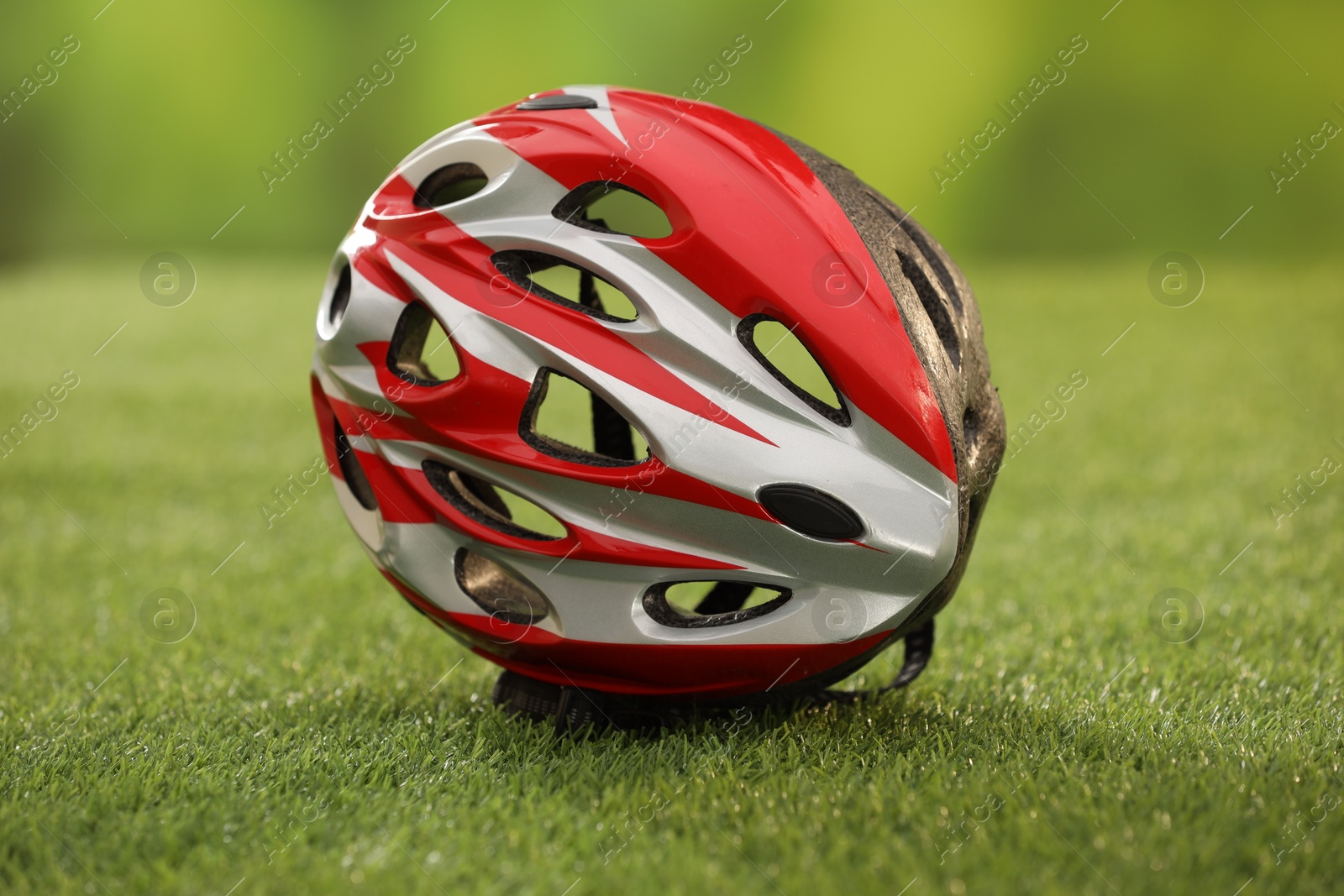 Photo of One colorful protective helmet on green grass