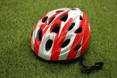 Photo of One colorful protective helmet on green grass