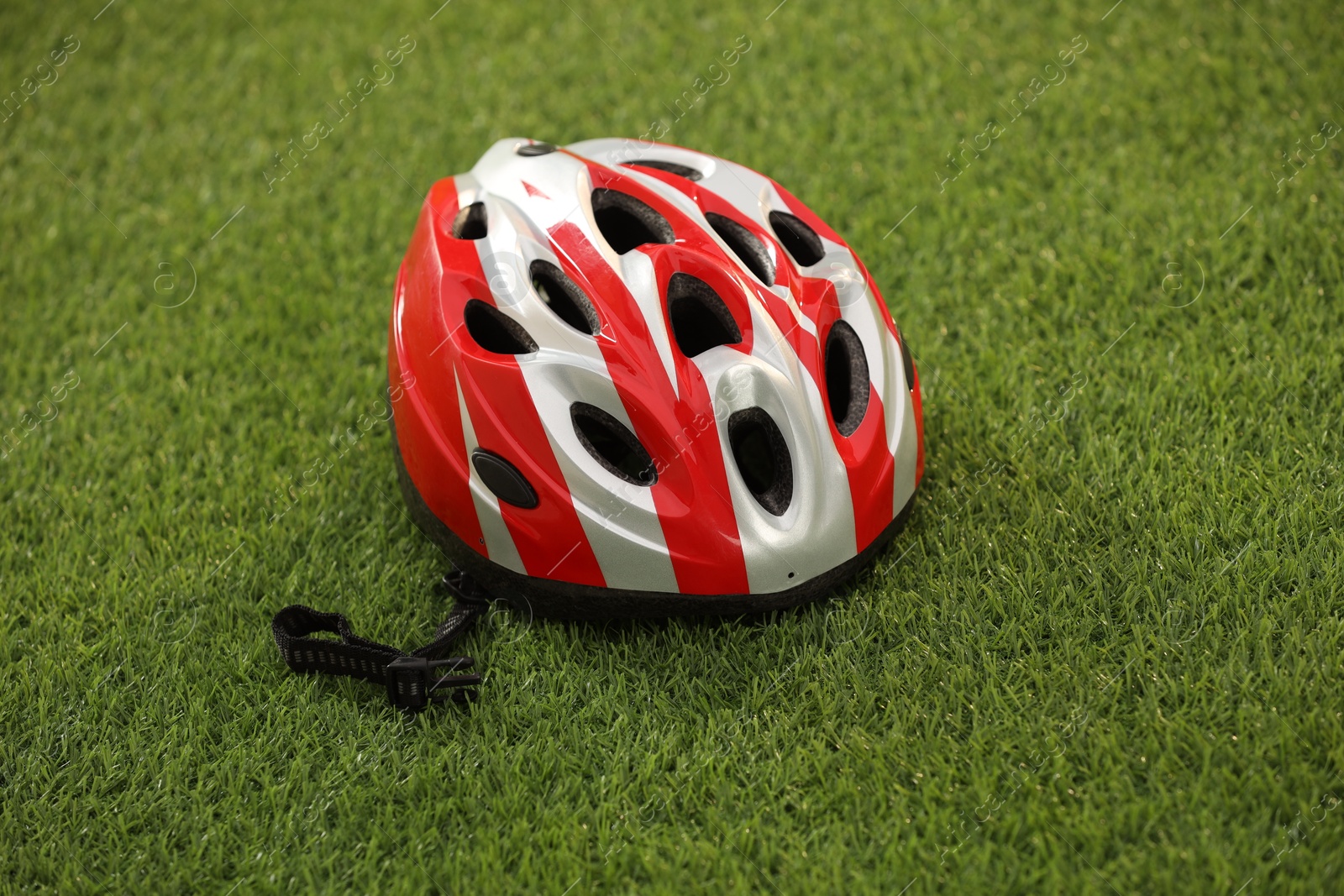 Photo of One colorful protective helmet on green grass