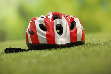 Photo of One colorful protective helmet on green grass