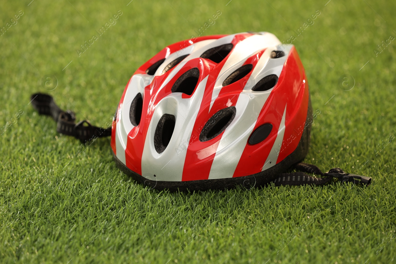 Photo of One colorful protective helmet on green grass