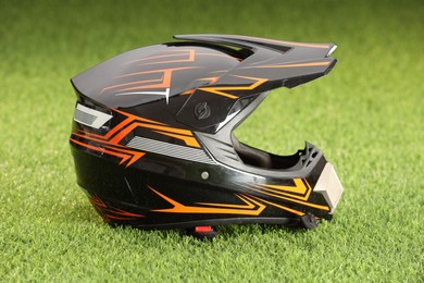 Photo of Modern motorcycle helmet with visor on green grass