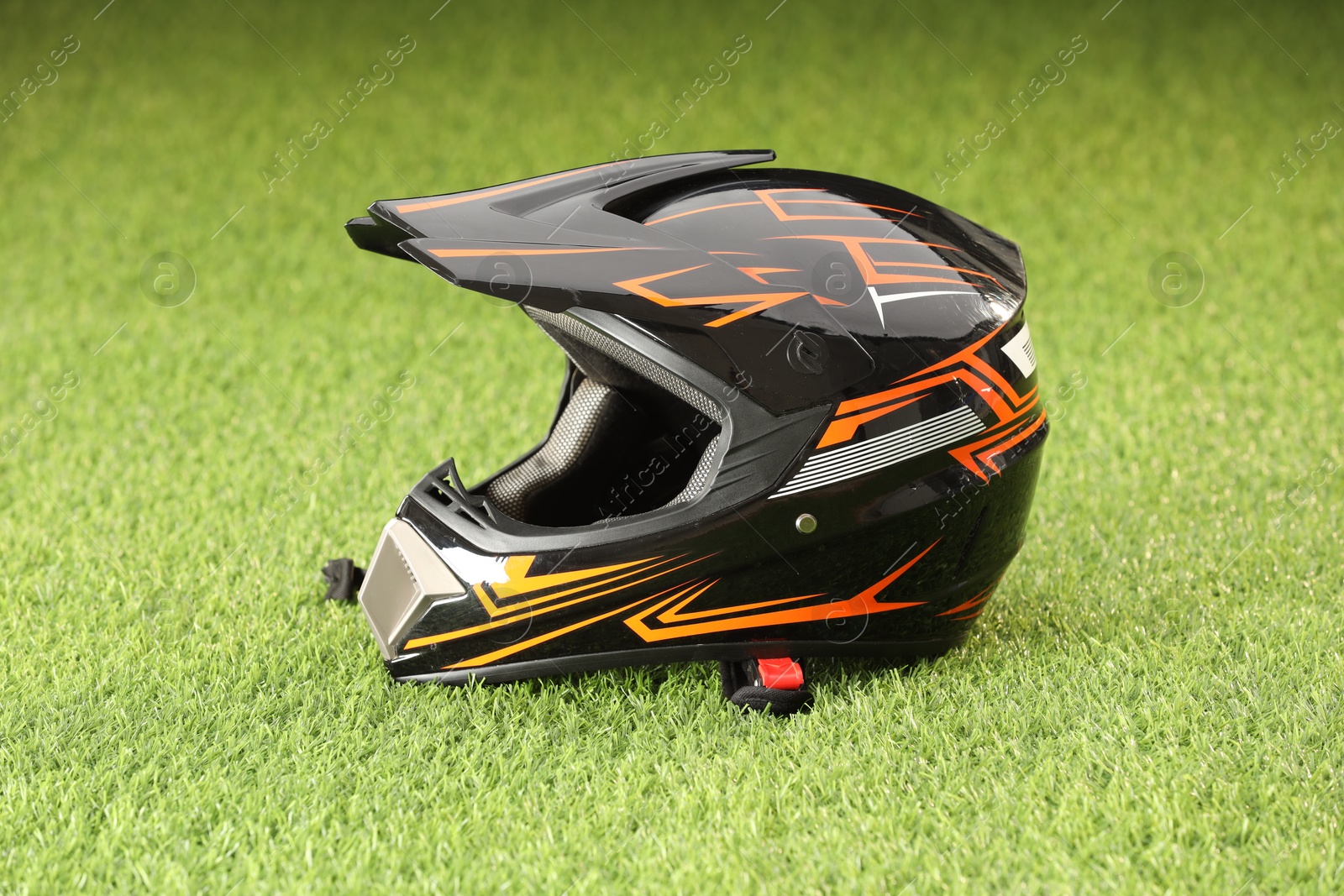 Photo of Modern motorcycle helmet with visor on green grass