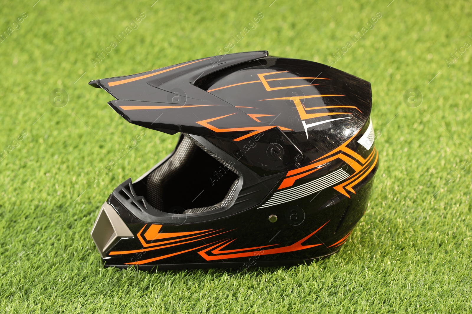 Photo of Modern motorcycle helmet with visor on green grass