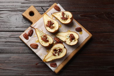 Tasty baked pears with nuts, blue cheese, thyme and honey on wooden table, top view