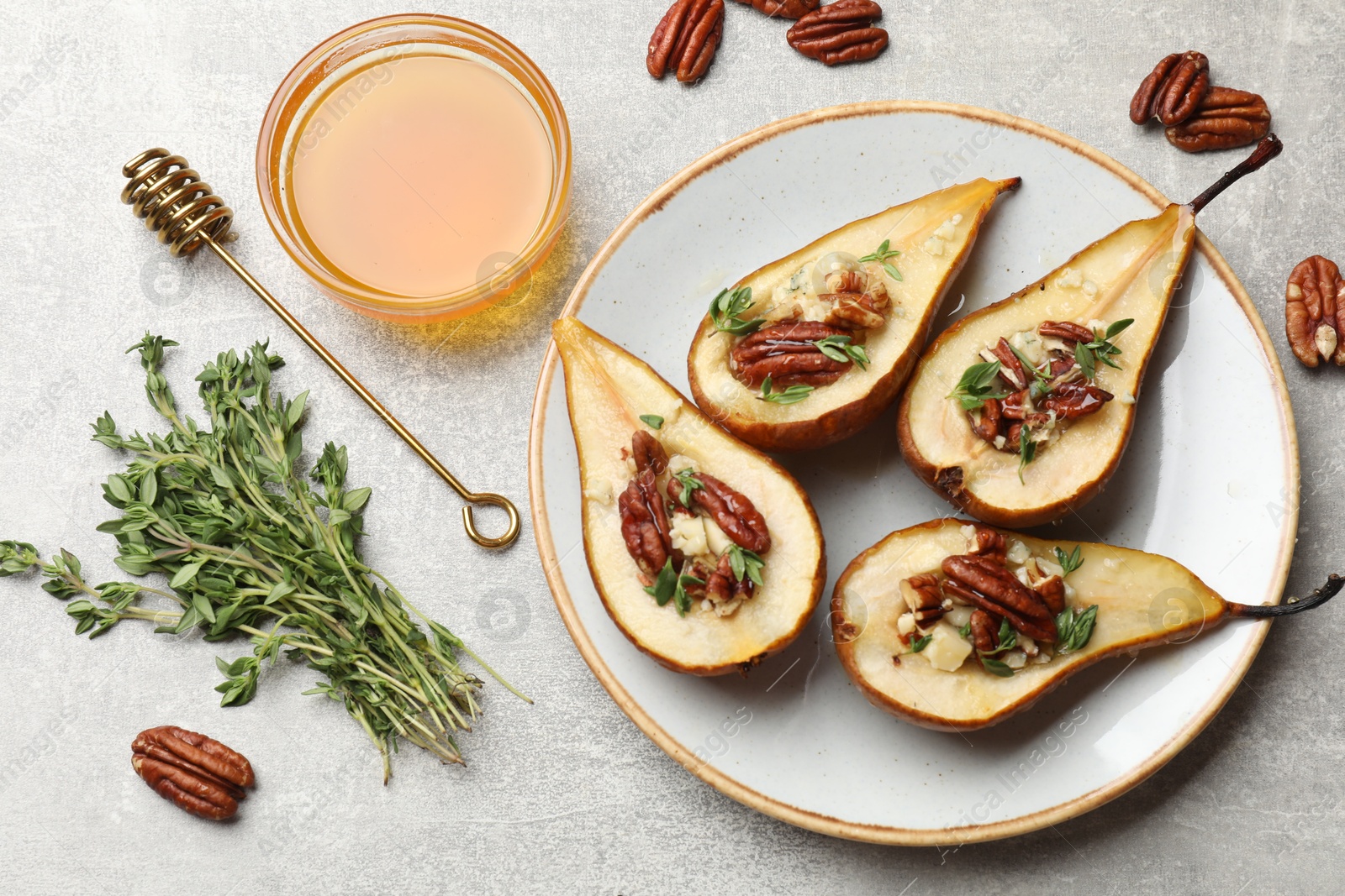 Photo of Tasty baked pears with nuts, blue cheese, thyme and honey on light grey table, flat lay