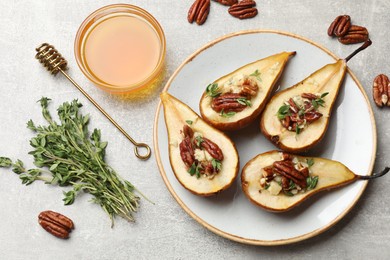 Photo of Tasty baked pears with nuts, blue cheese, thyme and honey on light grey table, flat lay