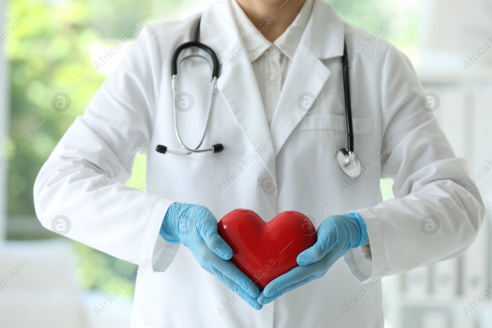 Photo of Doctor with red heart in clinic, closeup