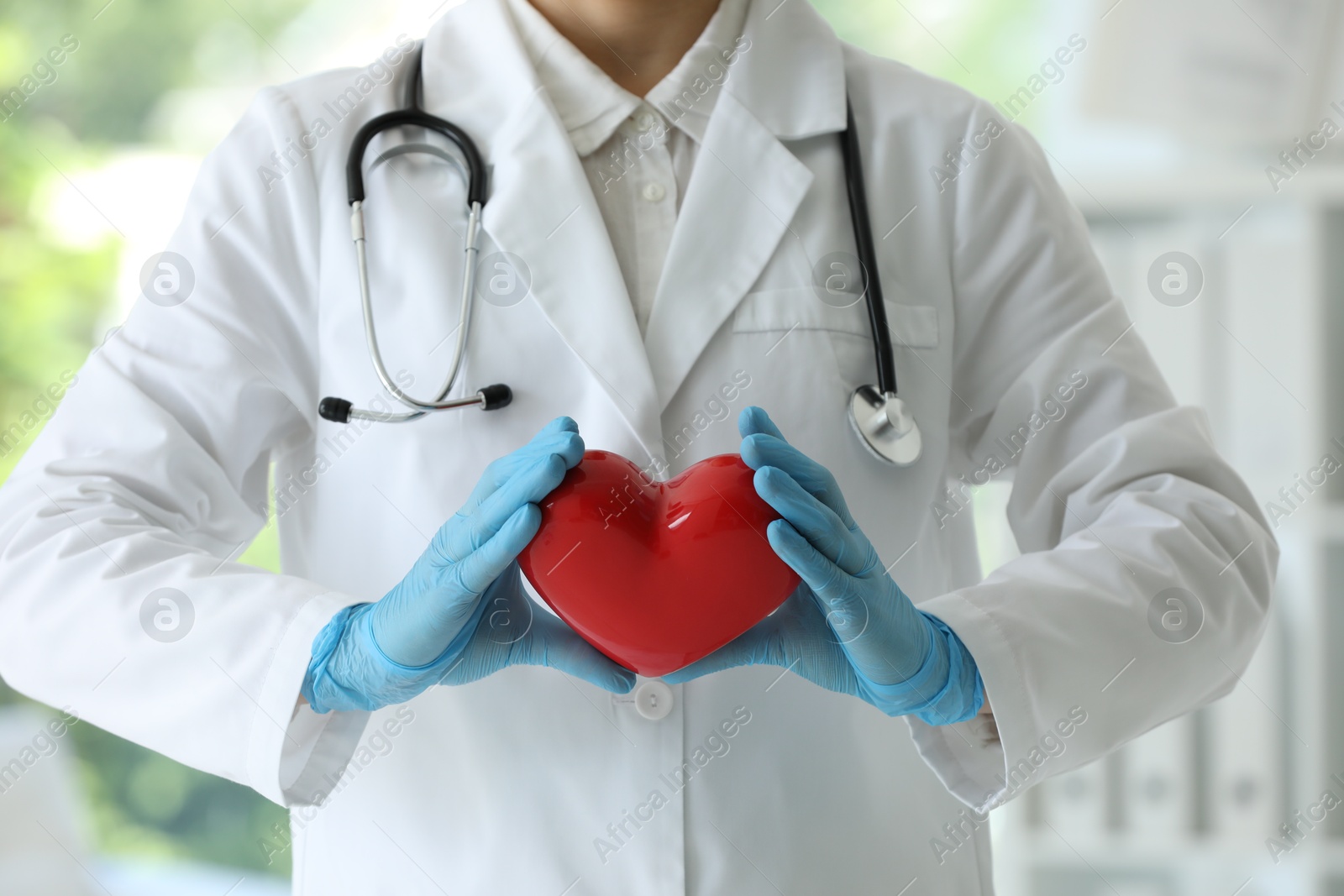 Photo of Doctor with red heart in clinic, closeup