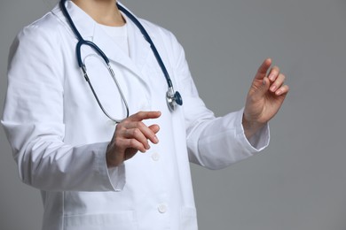 Doctor holding something on grey background, closeup