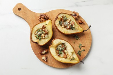 Photo of Tasty baked pears with nuts, blue cheese, thyme and honey on white table, top view