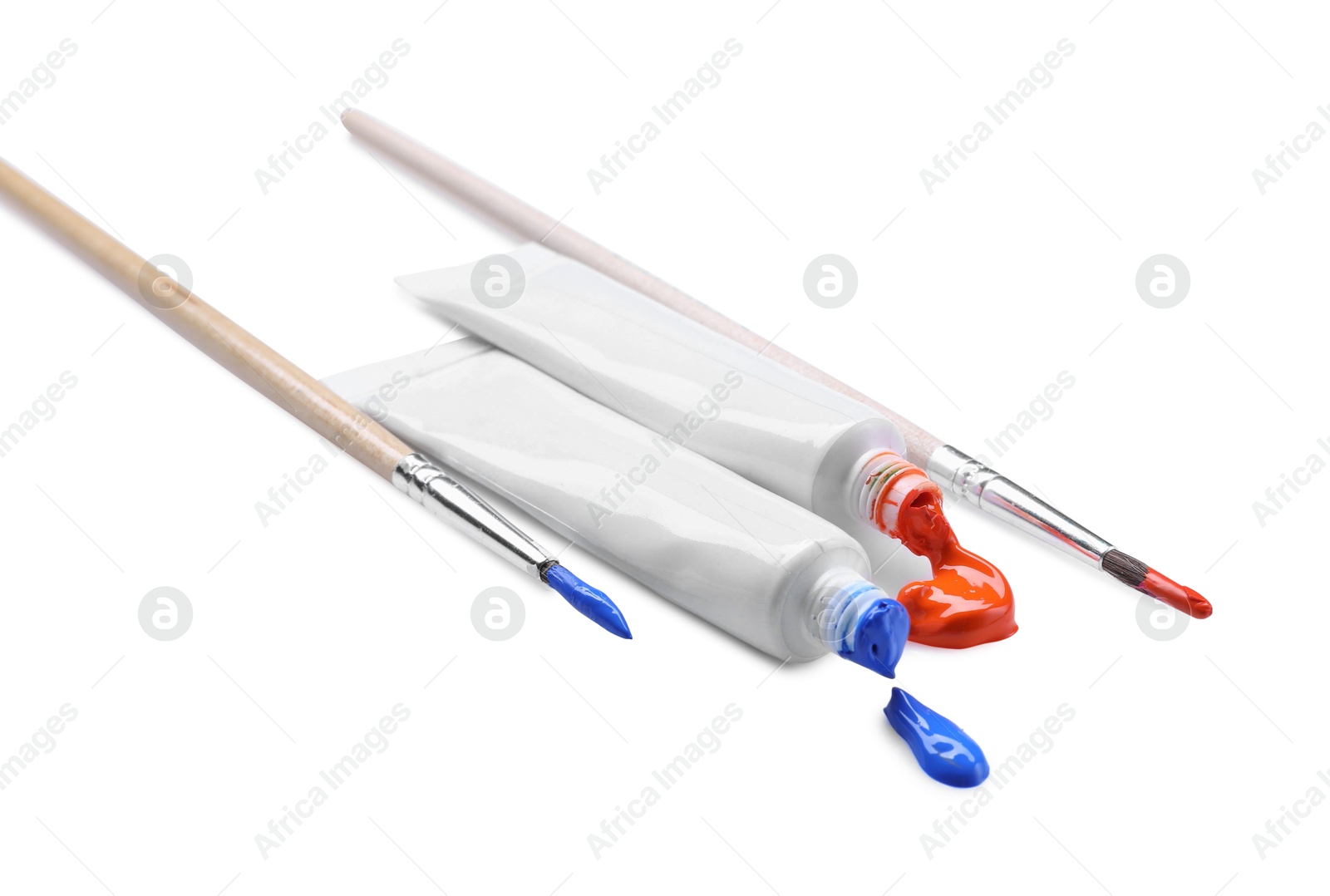 Photo of Tubes with colorful paints and brushes isolated on white