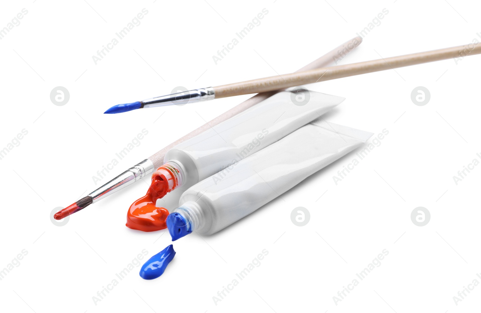 Photo of Tubes with colorful paints and brushes isolated on white