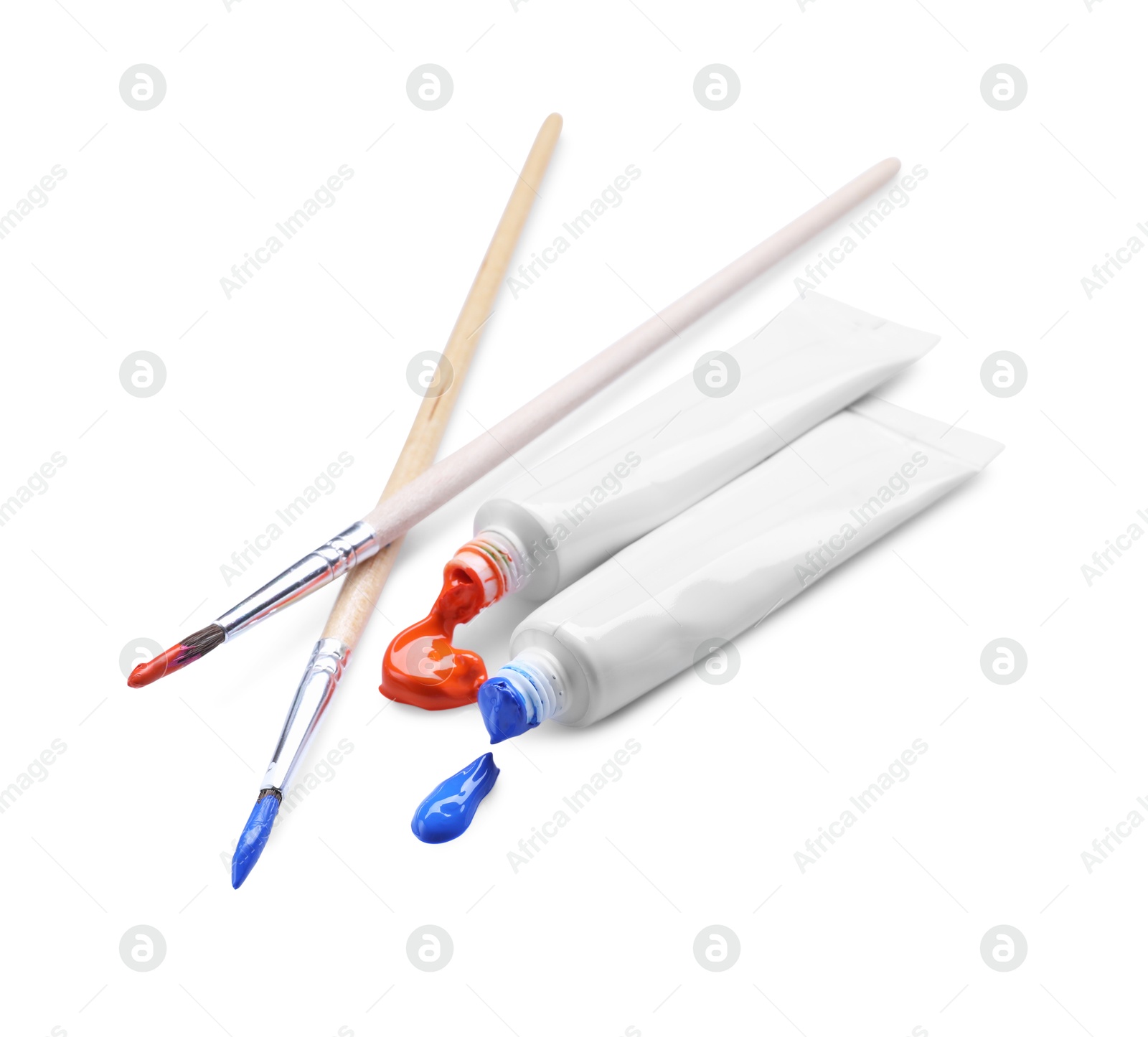 Photo of Tubes with colorful paints and brushes isolated on white