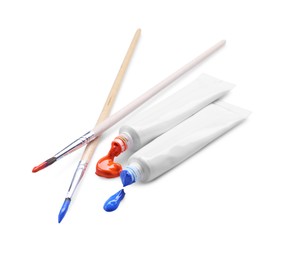 Photo of Tubes with colorful paints and brushes isolated on white