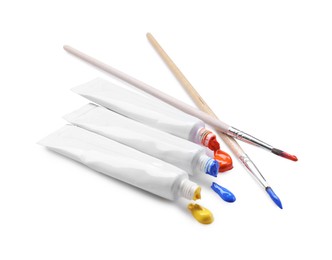 Photo of Tubes with colorful paints and brushes isolated on white