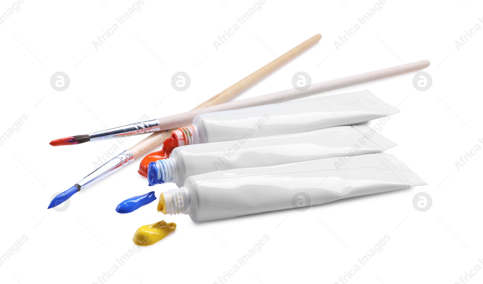 Photo of Tubes with colorful paints and brushes isolated on white