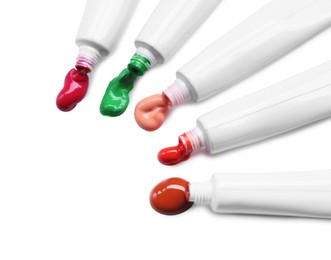 Photo of Tubes with colorful paints isolated on white, top view