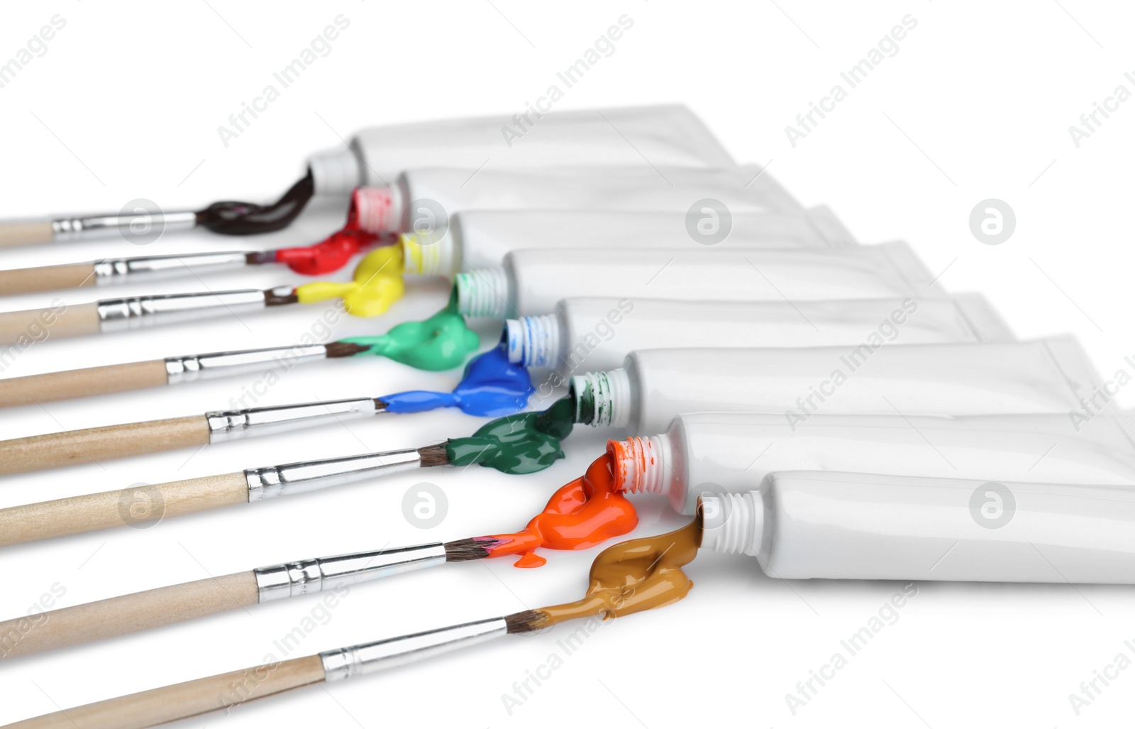 Photo of Tubes with colorful paints and brushes isolated on white