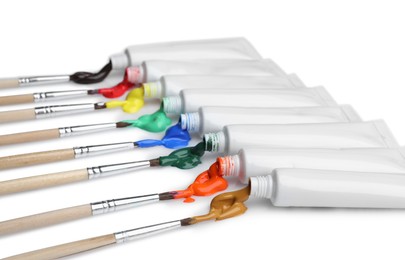 Tubes with colorful paints and brushes isolated on white