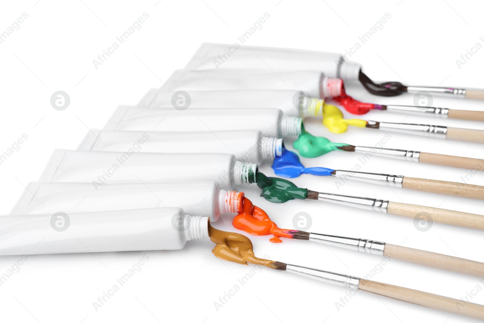 Photo of Tubes with colorful paints and brushes isolated on white