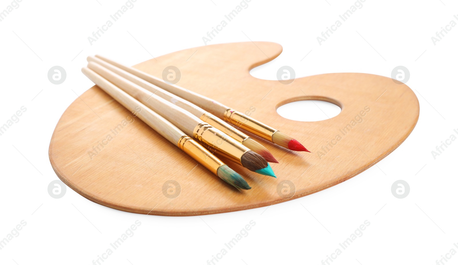 Photo of Brushes with paints and wooden palette isolated on white