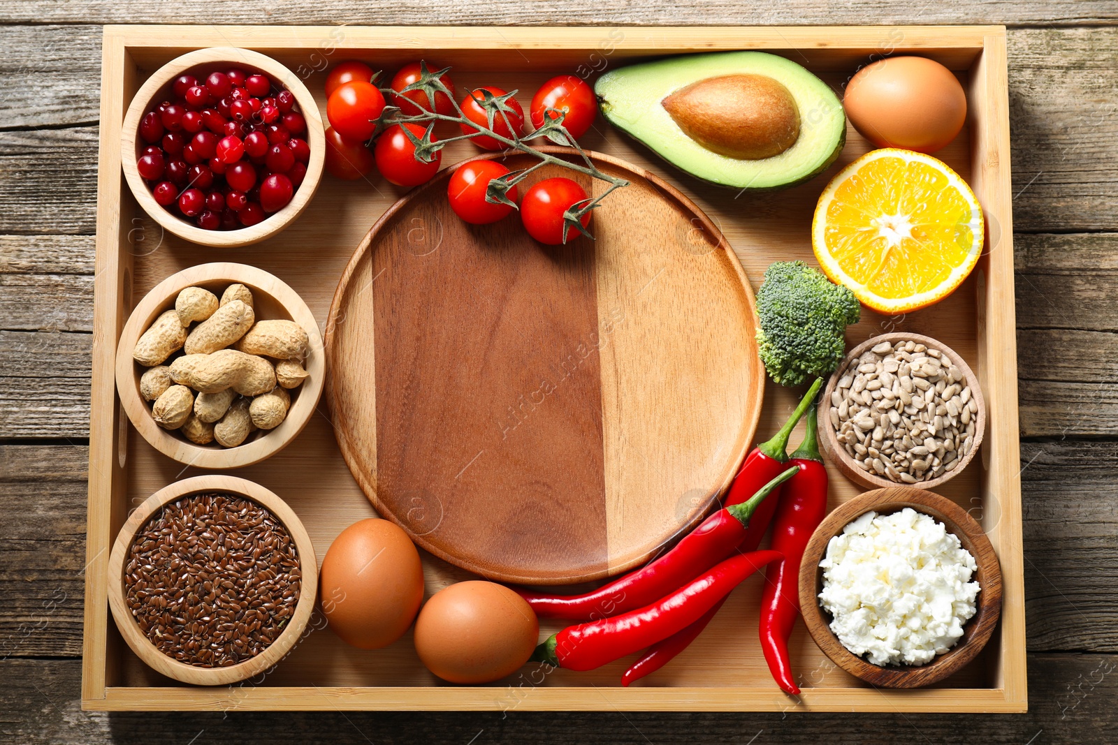 Photo of Tray with many different healthy food and plate on wooden table, top view. Space for text