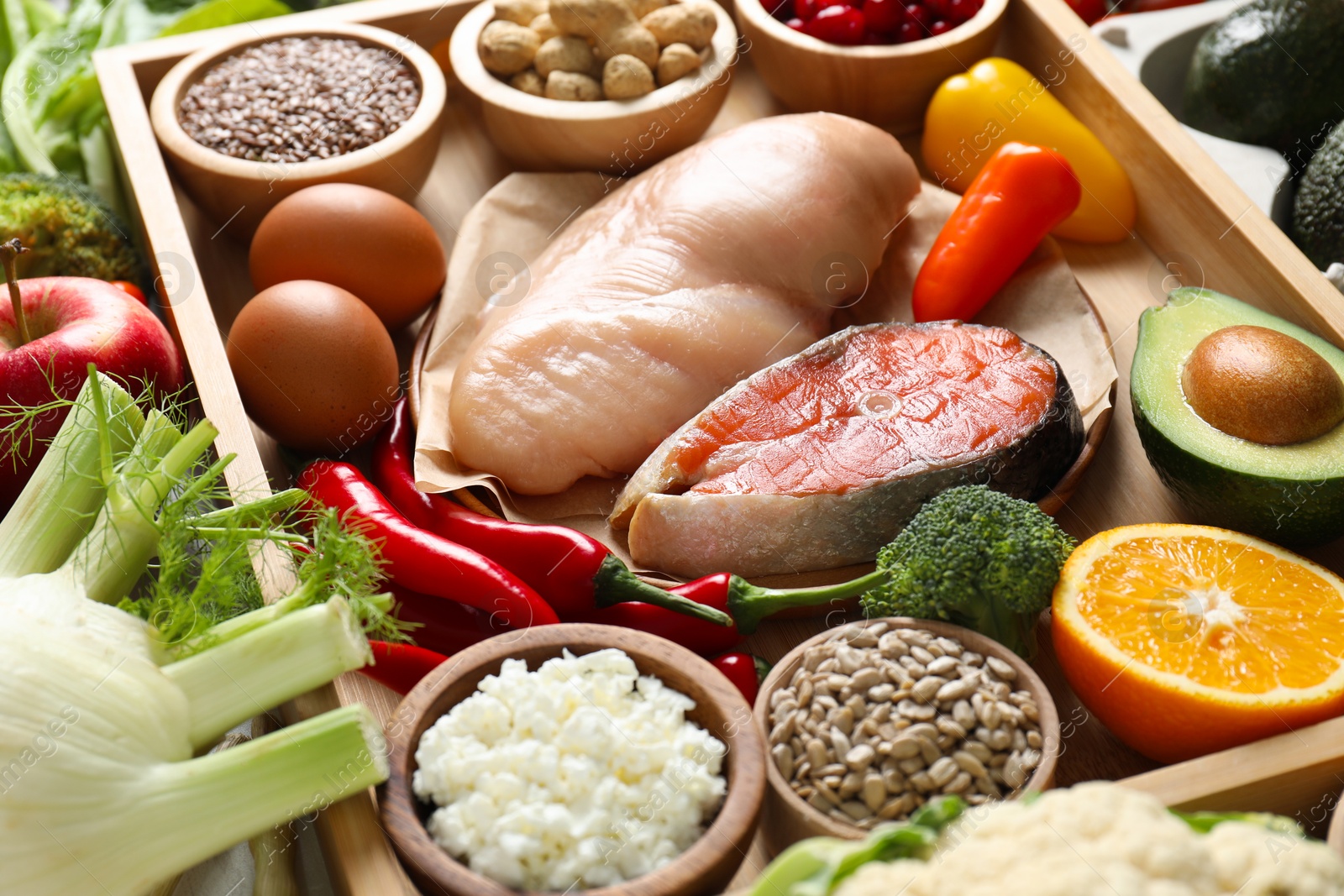 Photo of Raw chicken, salmon, seeds and other healthy food, closeup