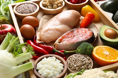 Photo of Raw chicken, salmon, seeds and other healthy food, closeup