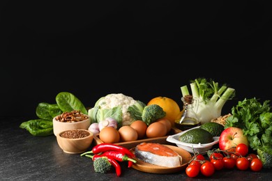 Many different healthy food on dark textured table against black background. Space for text