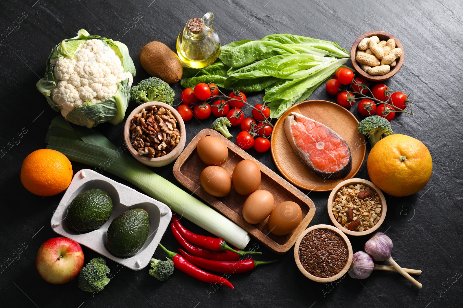 Photo of Many different healthy food on dark textured table, flat lay