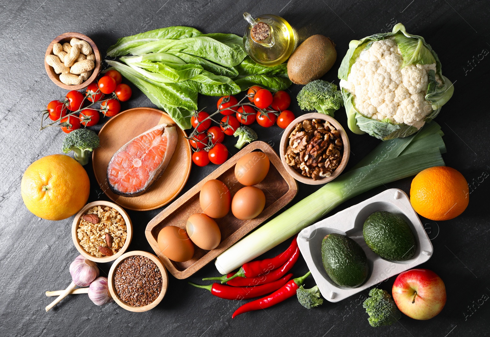 Photo of Many different healthy food on dark textured table, flat lay