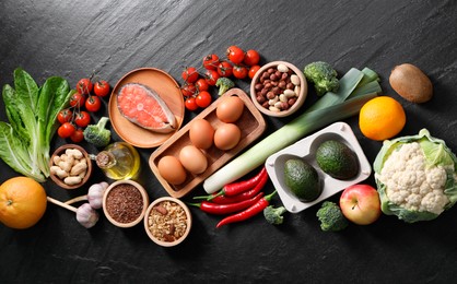 Many different healthy food on dark textured table, flat lay