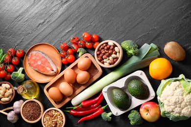 Photo of Many different healthy food on dark textured table, flat lay