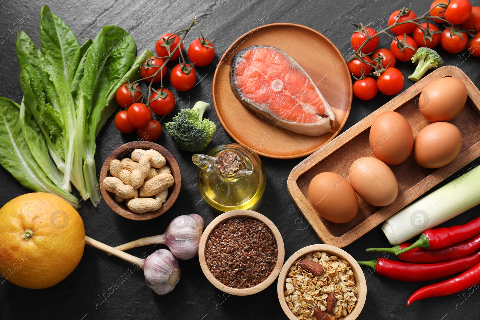 Photo of Many different healthy food on dark textured table, flat lay