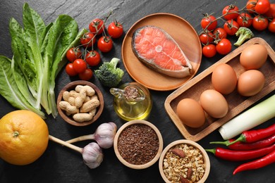 Many different healthy food on dark textured table, flat lay