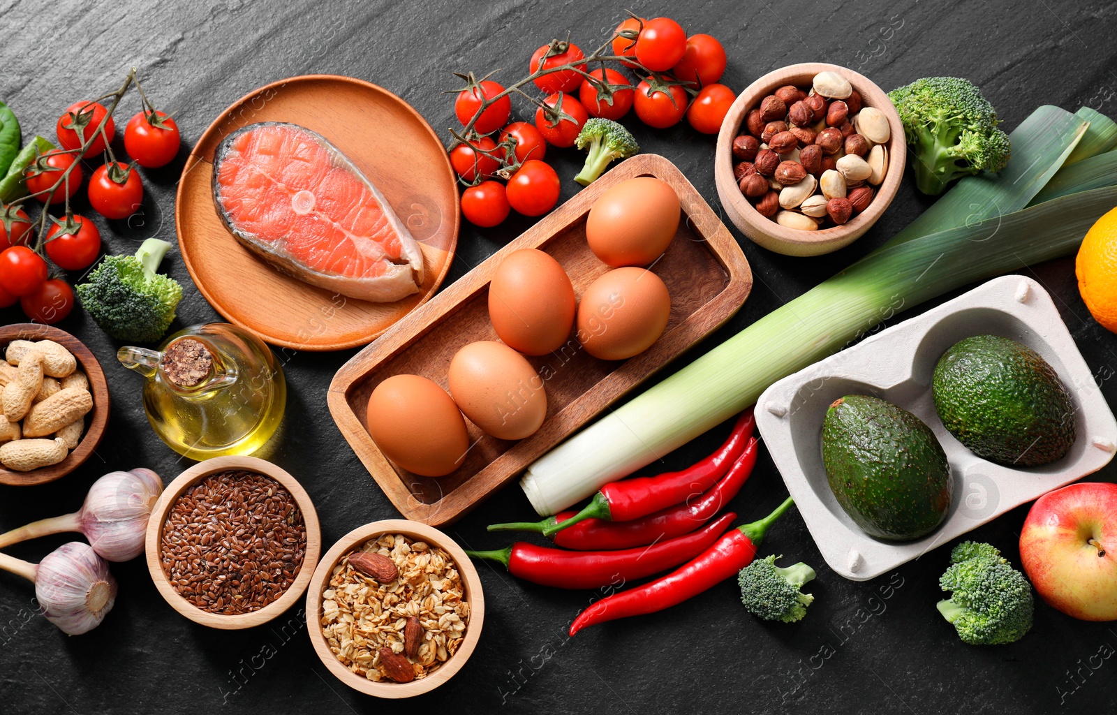 Photo of Many different healthy food on dark textured table, flat lay