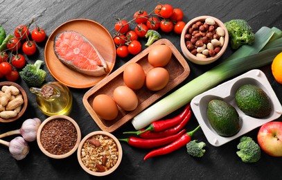 Photo of Many different healthy food on dark textured table, flat lay