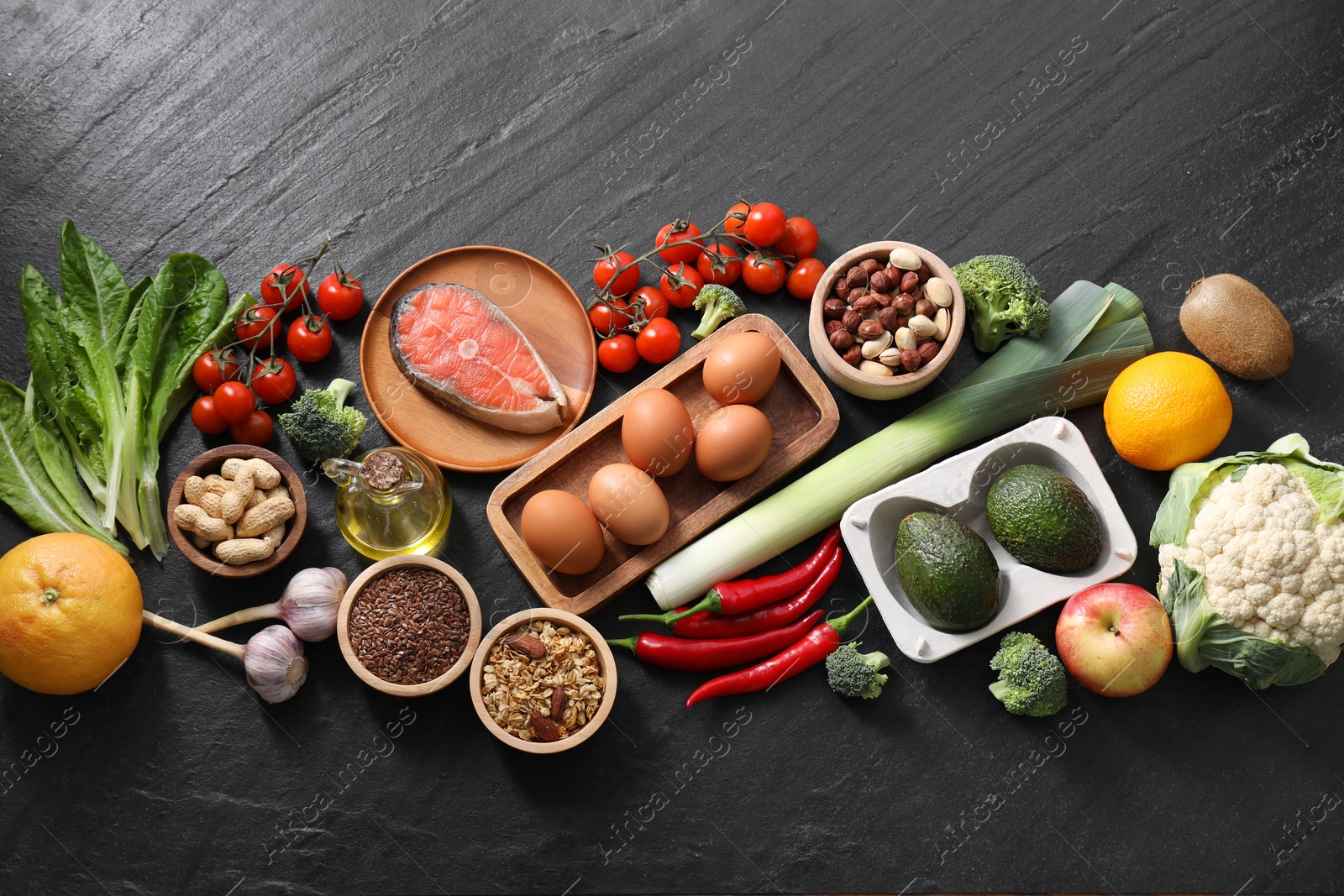 Photo of Many different healthy food on dark textured table, flat lay