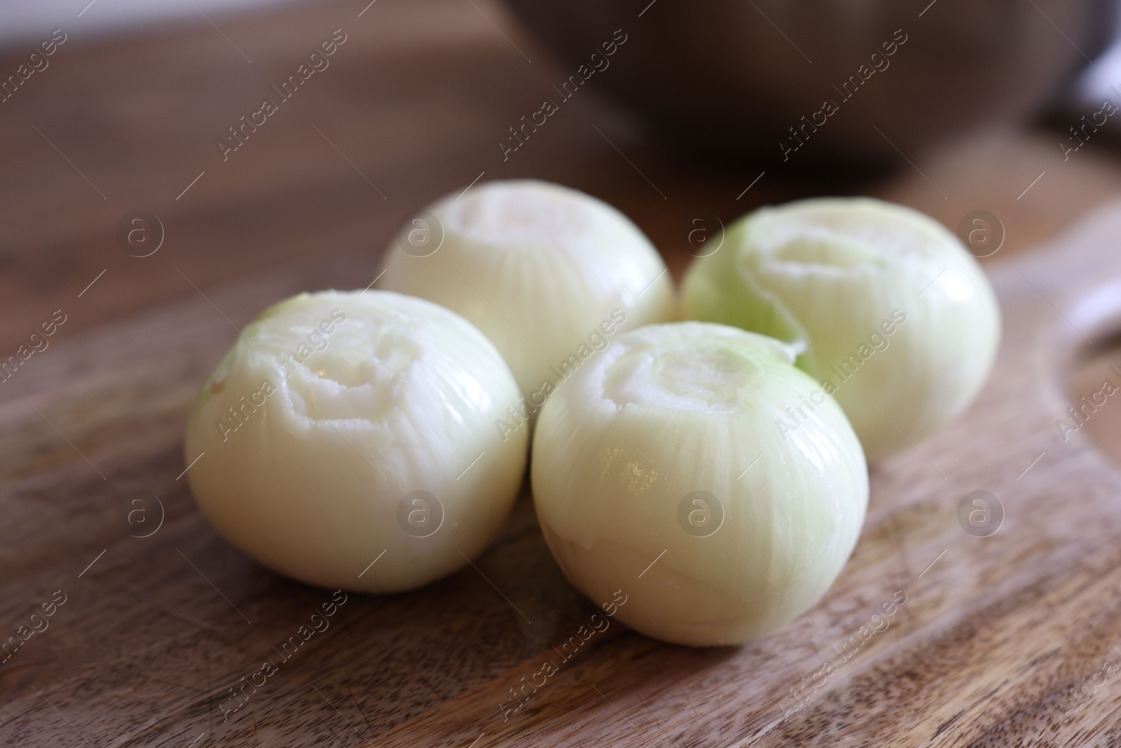 Photo of Fresh ripe onion bulbs on wooden table, closeup