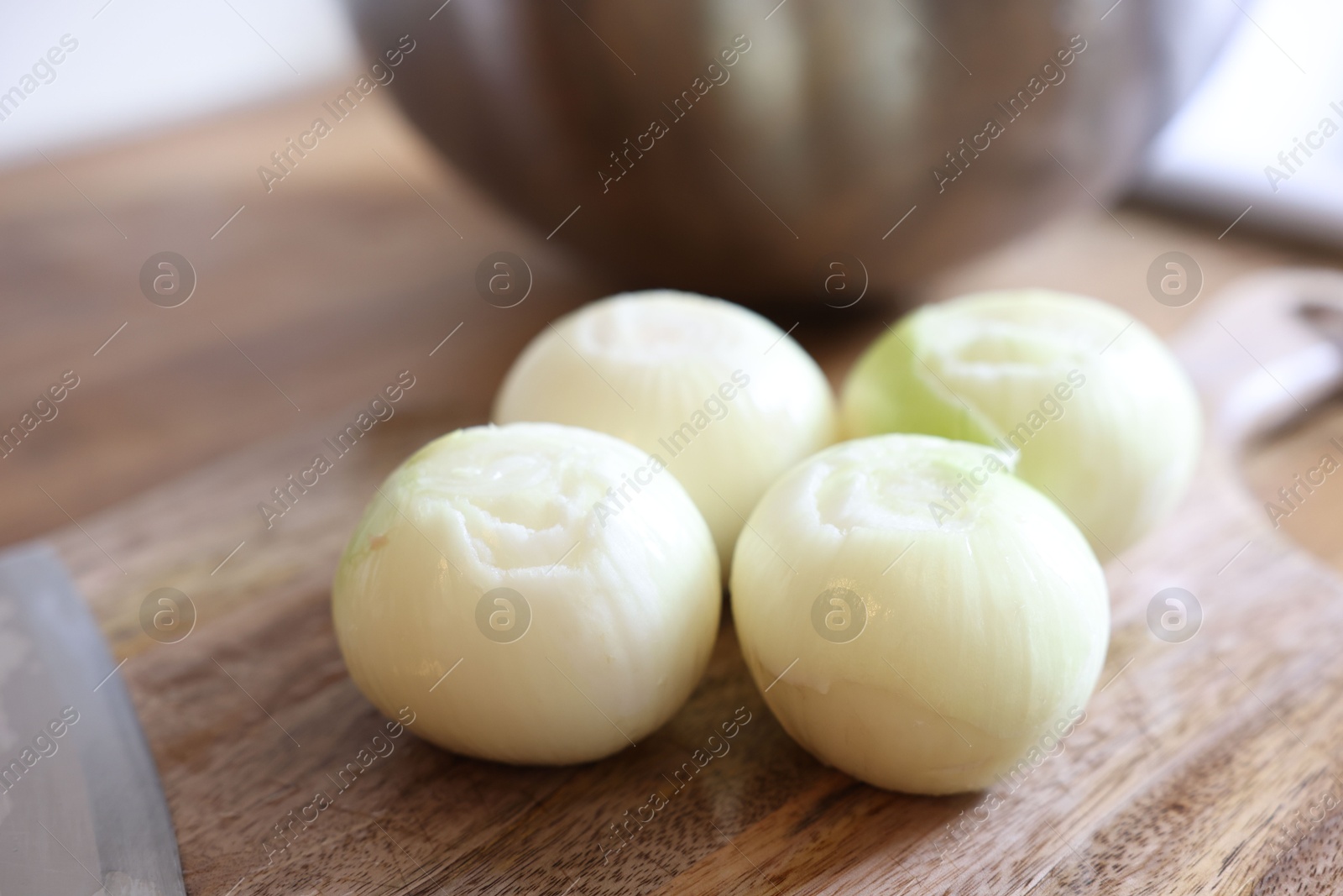 Photo of Fresh ripe onion bulbs on wooden table, closeup