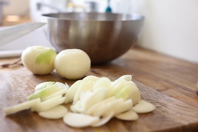 Fresh cut and whole onion on wooden table, closeup. Space for text