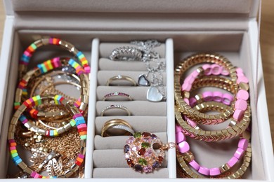 Photo of Jewelry box with stylish bracelets and other accessories on table