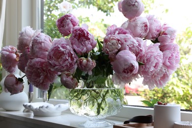 Beautiful pink peonies in vase on window sill. Interior design