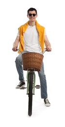 Smiling man in sunglasses riding bicycle with basket on white background